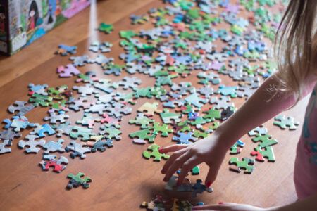 Image of a young child starting to put together a jigsaw puzzle