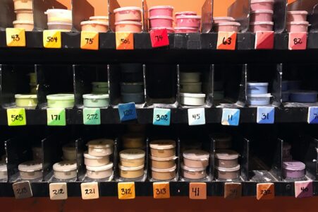 A wall of differently colored pots of paint at a pottery shop